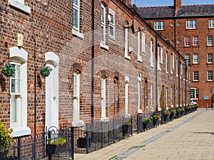 row of old brick built terraced house in the north of England Manchester, with black iron railings outside