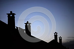 Row of old brick chimneys with moody evening sky