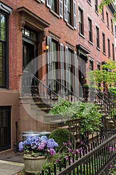 Row of old brownstone buildings along an empty sidewalk block in the Greenwich Village neighborhood of Manhattan, New