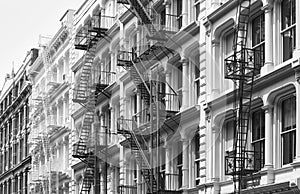 Row of old building with iron fire escapes, black and white picture of New York cityscape, USA