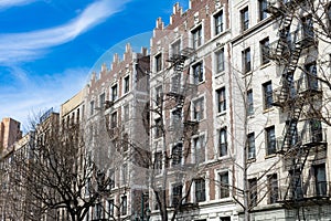 Row of Old Buildings with Fire Escapes in Harlem of New York City