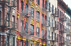 Row of old buildings with iron fire escapes, color toning applied, New York City, USA