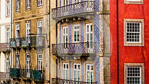 Row of old, colorful buildings with ornate balconies and tiles line a street in Porto, Portugal