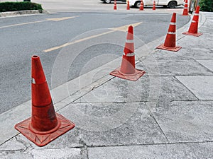 Row of Old Orange Plastic Traffic Cones Along the Road