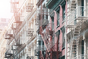 Row of old residential buildings with iron fire escapes, color toning applied, New York City, USA