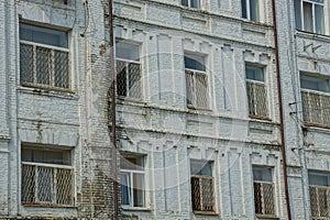 A row of old windows on a gray brick wall of the house