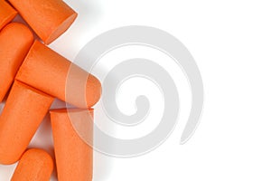 A row of orange earplugs on a white background. Close-up.Soft foam earplug
