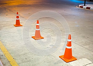 Row of orange traffic cones on concrete road