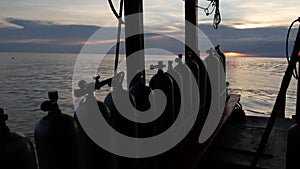 Row of oxygen tanks and diving equipment placed on modern boat in rippling ocean near Koh Tao resort, Thailand. Concept