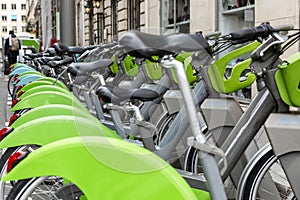 A row of parked city bikes. Eco-friendly tarnsport. Close-up