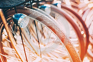 Row of parked vintage bicycles bikes for rent on sidewalk.