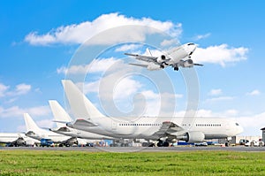 Row of passenger aircraft, airplane parked on service before departure. at the airport, other plane push back tow. One landing on