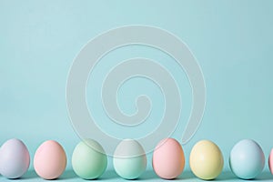 A row of pastel colored Easter eggs on a sky blue background