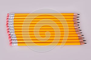 A row of pencils enter top left at an angle with erasers flush