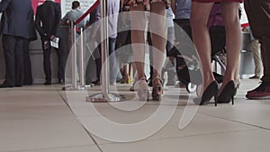 Row of people waiting in an airport. Feet of people in line at the airport