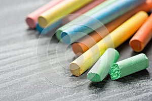 Row Pile of Multicolored Chalks Crayons on Dark Scratched Blackboard. Back to School Business Creativity Graphic Design Crafts Kid