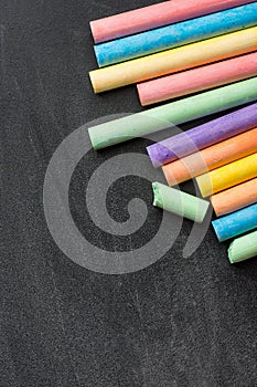 Row Pile of Multicolored Chalks Crayons on Dark Scratched Blackboard. Back to School Business Creativity Graphic Design