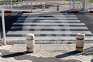 A row of pillars along the road for the safe passage of pedestrians along the sidewalk.