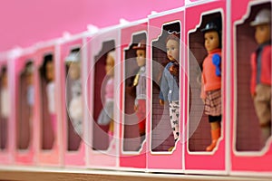 Row of pink tin boxes / containers for children, on the shop shelfyRow of pink boxes with toy dolls on the shop shelf