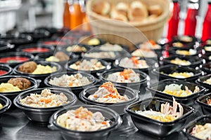 Row of plastic disposable lunch box with healthy natural food. Soups, cream soup, main course with side dish, salads