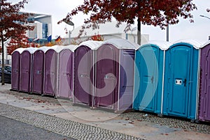 A row of portable rent toilets