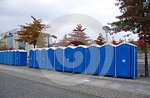 A row of portable rent toilets