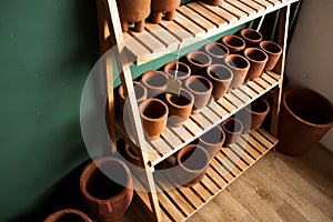 A Row Of Pottery Pots On A Wooden Shelf
