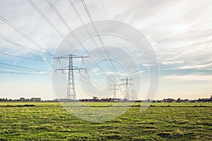 Row of power pylons with high voltage lines in a Dutch polder landscape