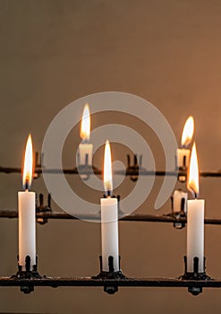 Stand of burning prayer candles in old church