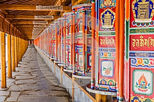 Row of praying wheels around Labrang Monastery in Xiahe town, Gansu province, Chi