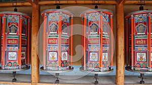 Row of praying wheels around Labrang Monastery in Xiahe town, Gansu province, China