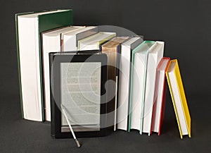 Row of printed books with electronic book reader