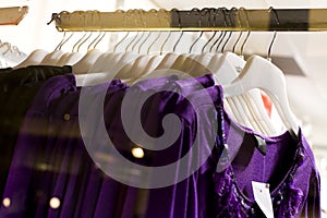 Row of purple blouse garments on display