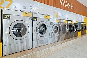 A row of qualified coin-operated washing machines in a public store.