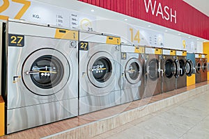 A row of qualified coin-operated washing machines in a public store.