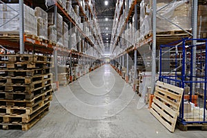 Row with racks of goods on shelves inside warehouse