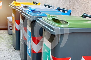 Recycling bins along the exterior wall of a house photo