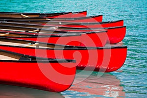 Row of red canoes in lake