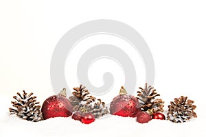Row of red christmas ball decorations and pine cones