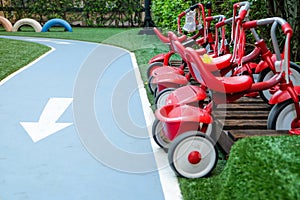 Row of red tricycles parked at playground