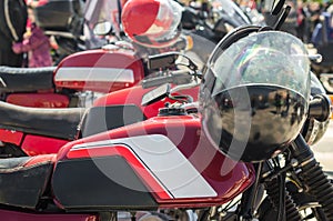 Row of red vintage motorcycle cafes racer with helmets in competitions