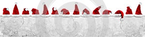 row of red white santa claus christmas xmas hat on empty concrete wall