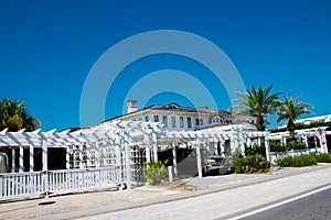 Row of residential, vacation beach houses with white pergola, picket fence front yard curb appeal along scenic 30A road in Santa