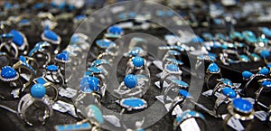 Row of rings with blue stone on the shelf of jewerely store