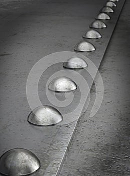 Row of rivets on the metal grunge background