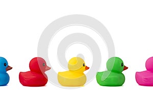 A row of rubber ducks on a white background. Bright colored rubber ducks in a line. Rubber ducks in a row isolated on a white