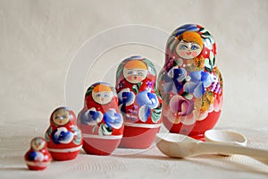 Row Russian Matryoshkas and two wooden spoons