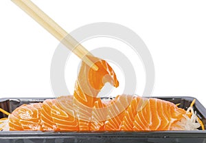 A row of Salmon Sashimi on vegetable sliced in small black tray, a bamboo chopsticks is clamping one piece up, salmon is a high