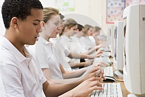 Row of schoolchildren studying on computers