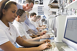 Row of schoolchildren studying on computers